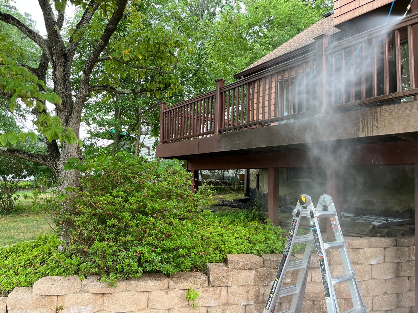 Deck railing and boards being power washed